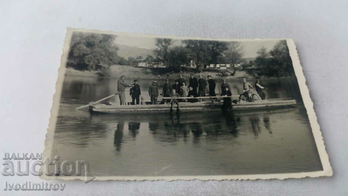 Fotografie Femeie și bărbați pe un feribot în râu