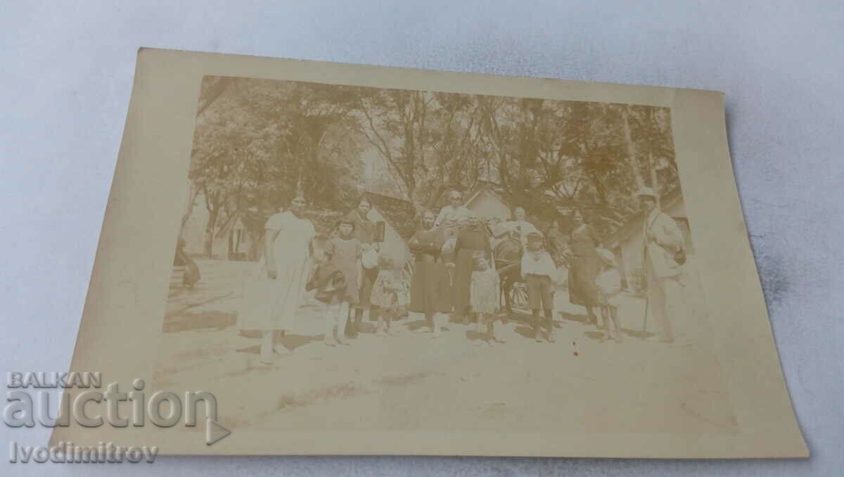 Fotografie Doi bărbați femei și copii în fața unui bungalou