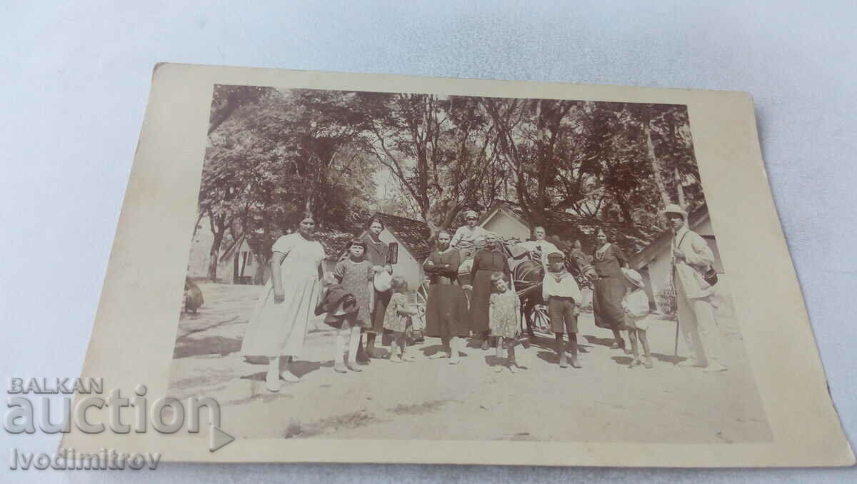 Fotografie Doi bărbați femei și copii în fața unui bungalou