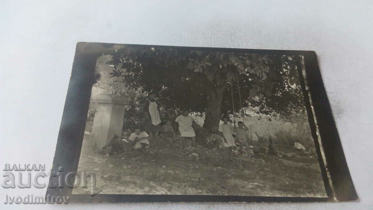 Photo Two women and children under a tree by a fountain