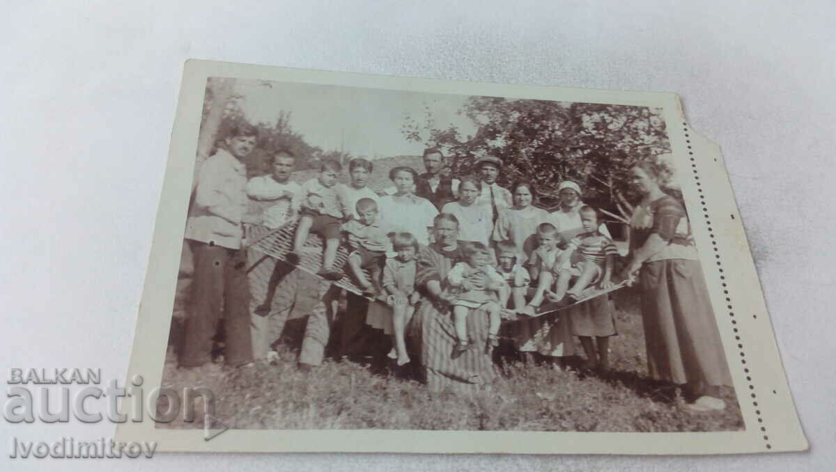 Φωτογραφία Άνδρες γυναίκες και παιδιά γύρω από μια αιώρα στην αυλή