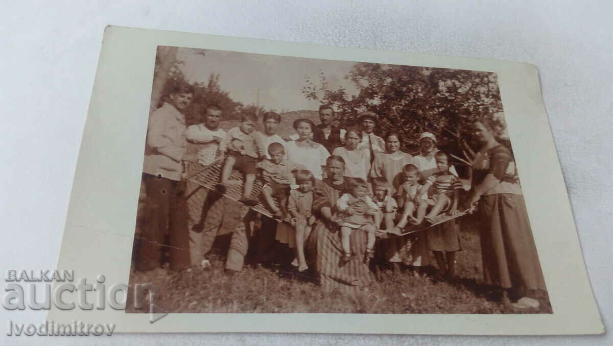 Φωτογραφία Άνδρες γυναίκες και παιδιά γύρω από μια αιώρα στην αυλή