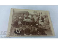 Снимка Мъже жени и деца на маса в двора на къщата си