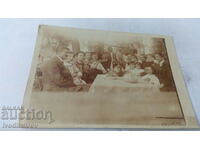 Photo Men, women and children at a table with food, 1912