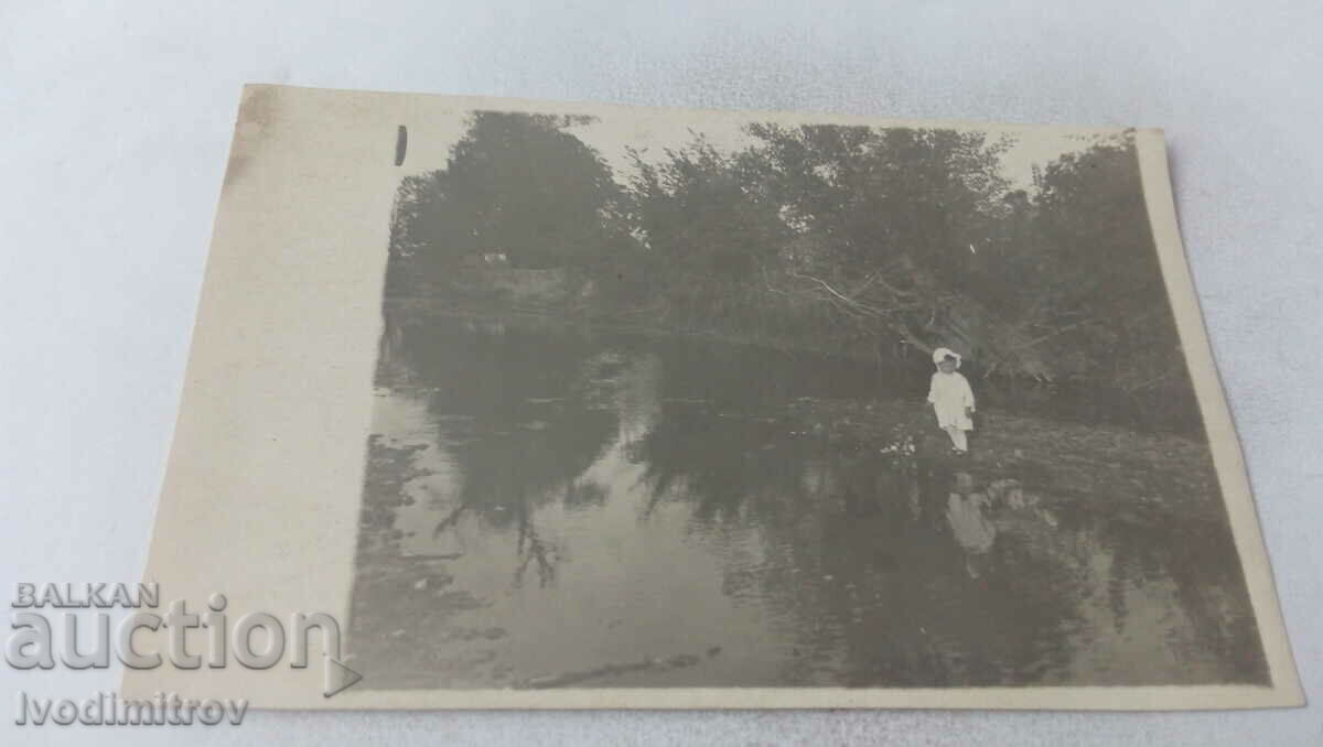 Fotografie Fetiță îmbrăcată în alb lângă râu