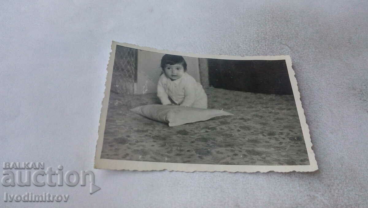 Foto Bebeluş cu o pernă pe podea