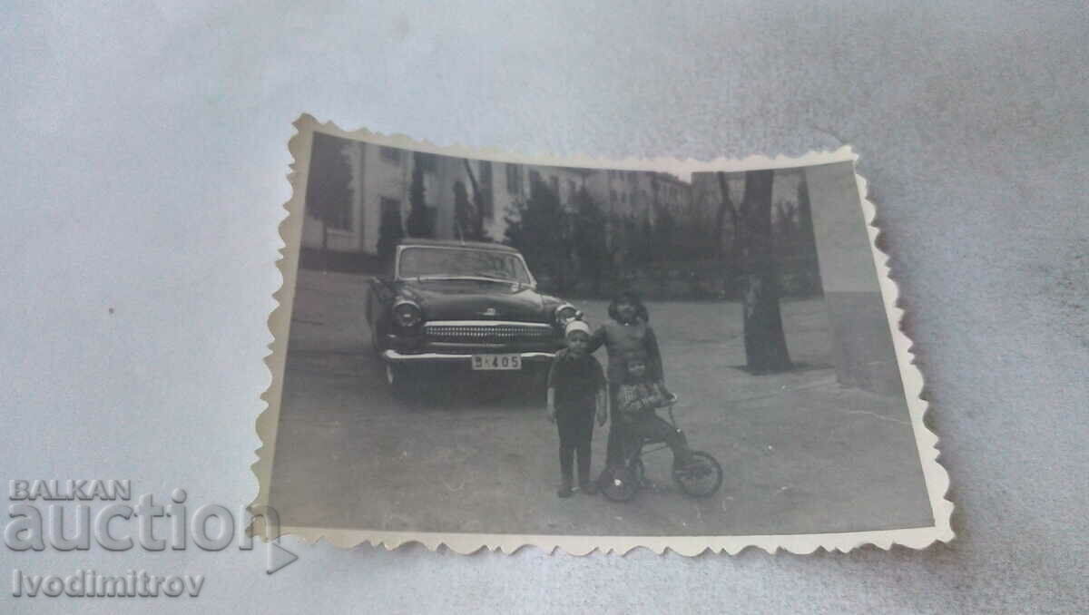 Foto Trei copii cu o bicicletă retro pentru copii în fața Volgăi
