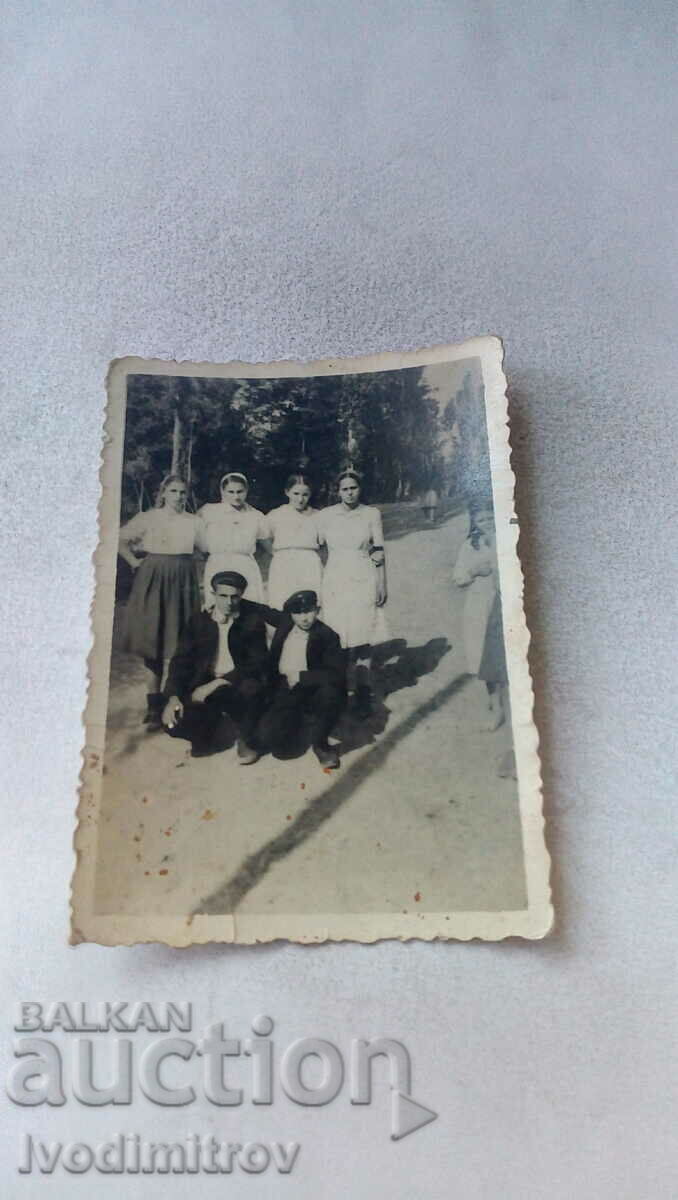 Foto Doi tineri și patru fete pe o alee din parc
