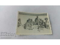 Φωτογραφία Άνδρες και γυναίκες που παίζουν χαρτιά στην παραλία