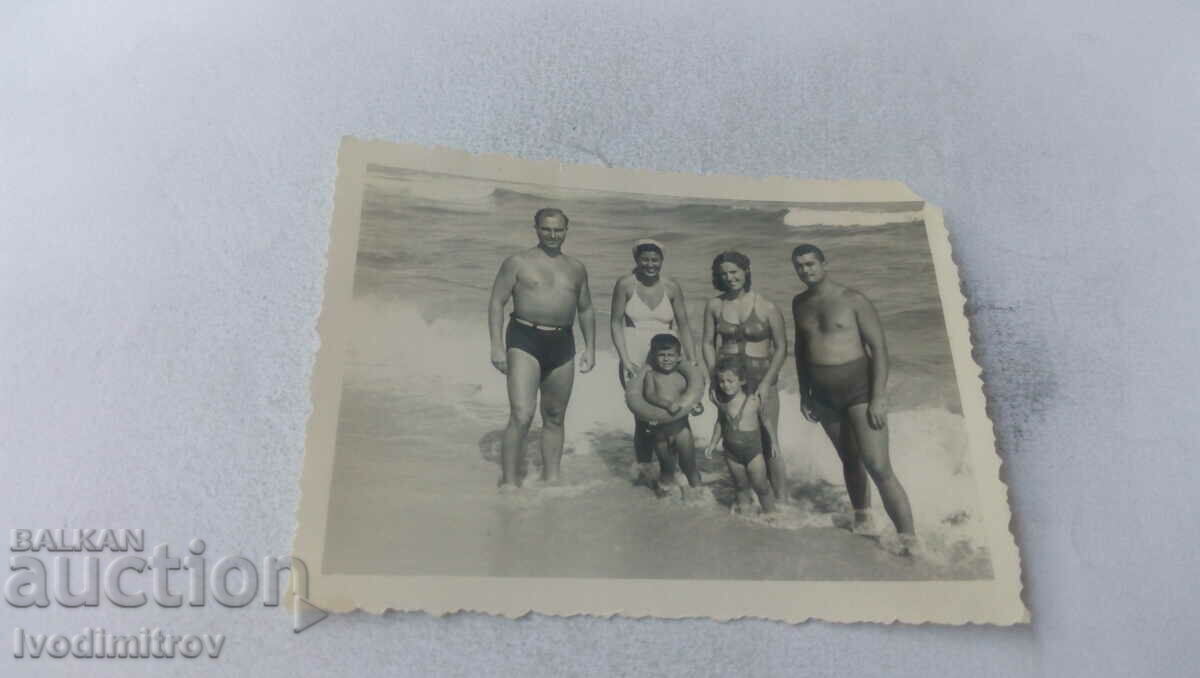 Foto Doi bărbați, două femei și doi copii pe plajă