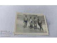 Foto Doi bărbați, două femei și doi copii pe plajă