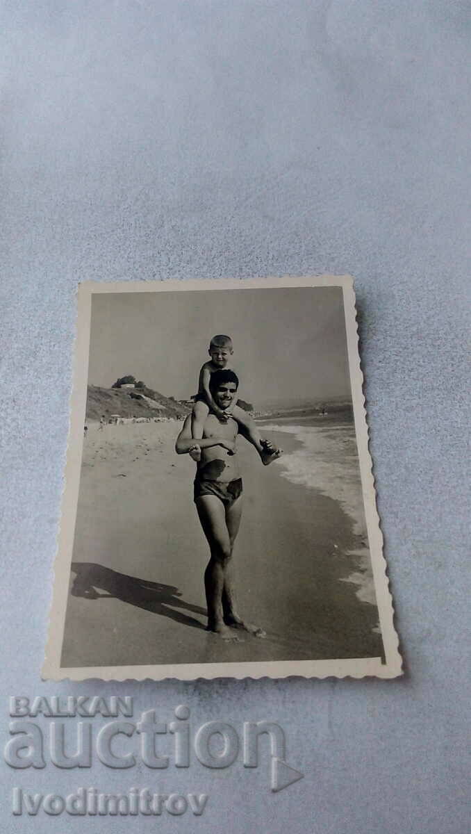 Снимка Мъж и малко момче на брега на морето