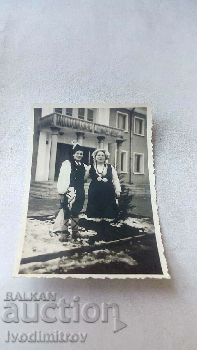 Photo Man and woman in folk costumes in winter