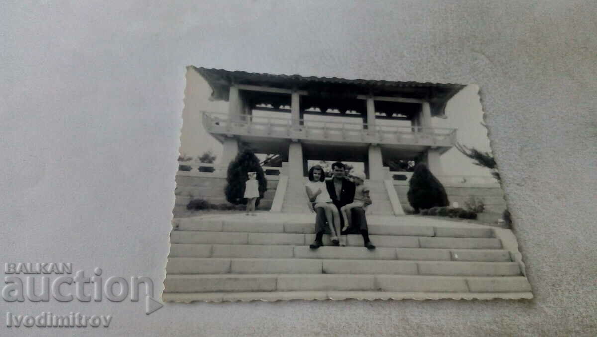 Photo A man and two children on the stairs in front of a pagoda