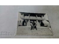 Photo A man and two children on the stairs in front of a pagoda
