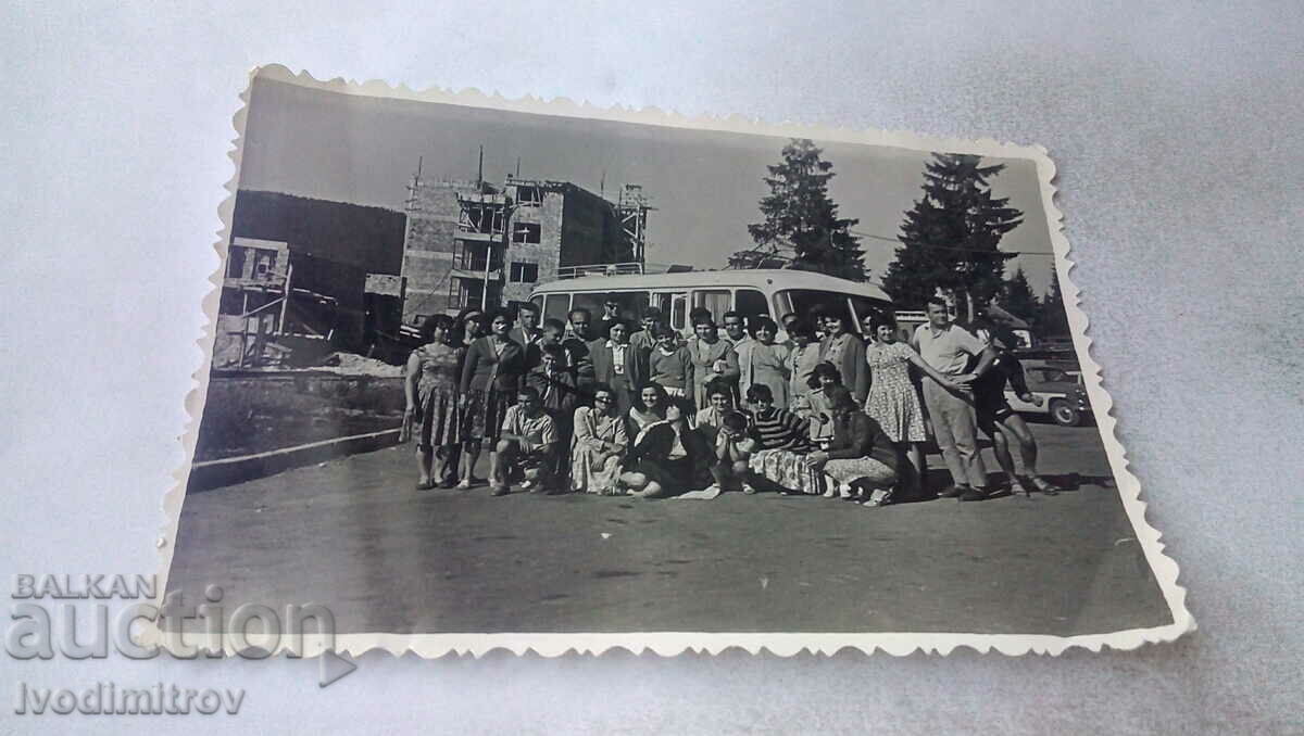 Photo Men women in front of a vintage bus