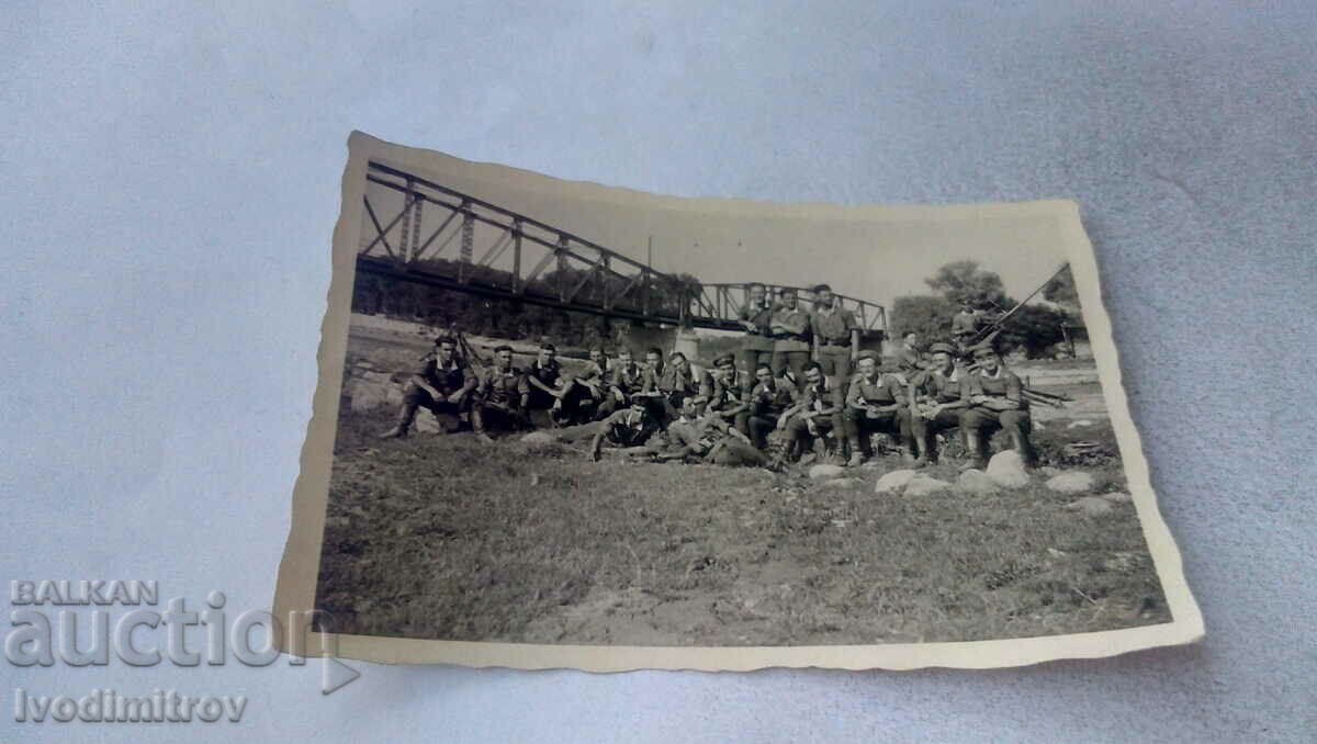 Φωτογραφία Στρατιώτες κάτω από μια σιδηροδρομική γέφυρα πάνω από ένα ποτάμι