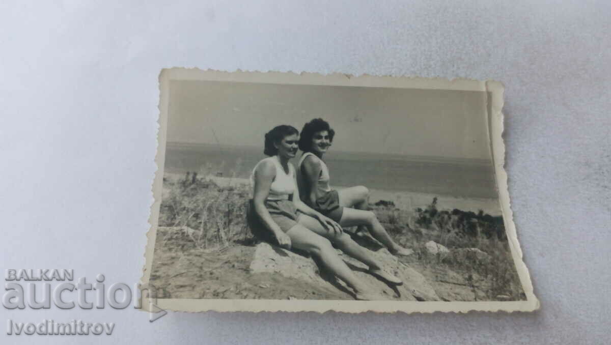 Φωτογραφία Δύο νεαρές γυναίκες στους αμμόλοφους στην παραλία