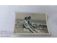 Φωτογραφία Δύο νεαρές γυναίκες στους αμμόλοφους στην παραλία