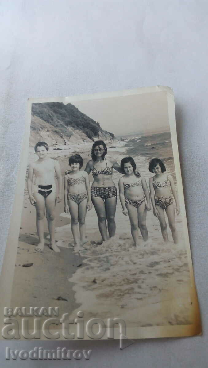 Photo Woman three girls and a boy on the beach