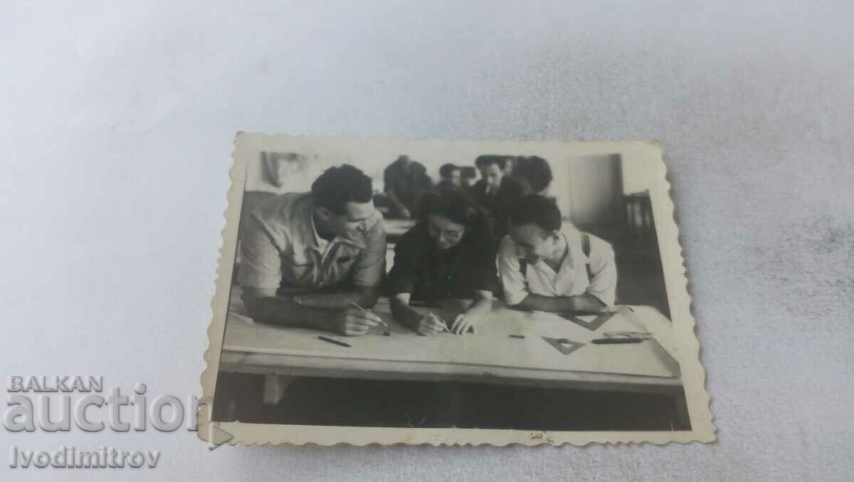 Photo Two men and a young woman at the drawing table