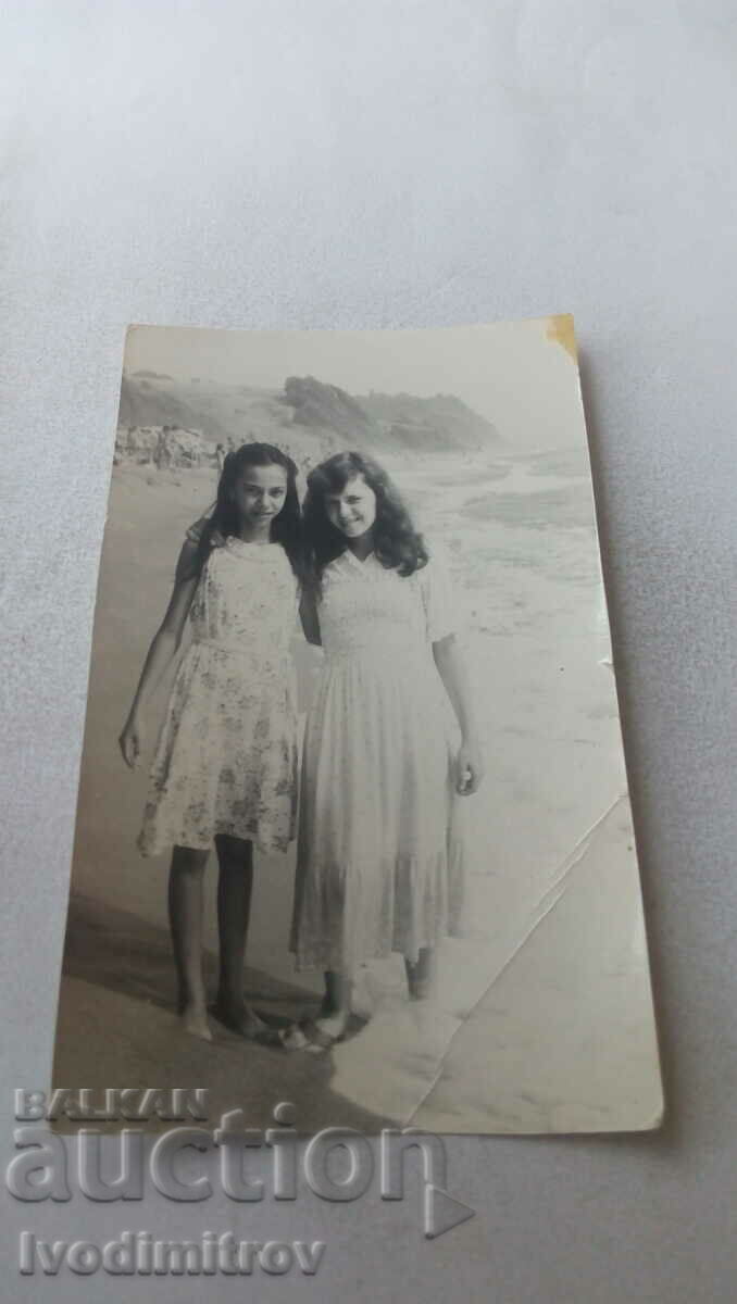Φωτογραφία Δύο νεαρά κορίτσια με λευκά φορέματα στην παραλία