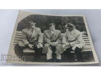 Photo Three men sitting on a park bench