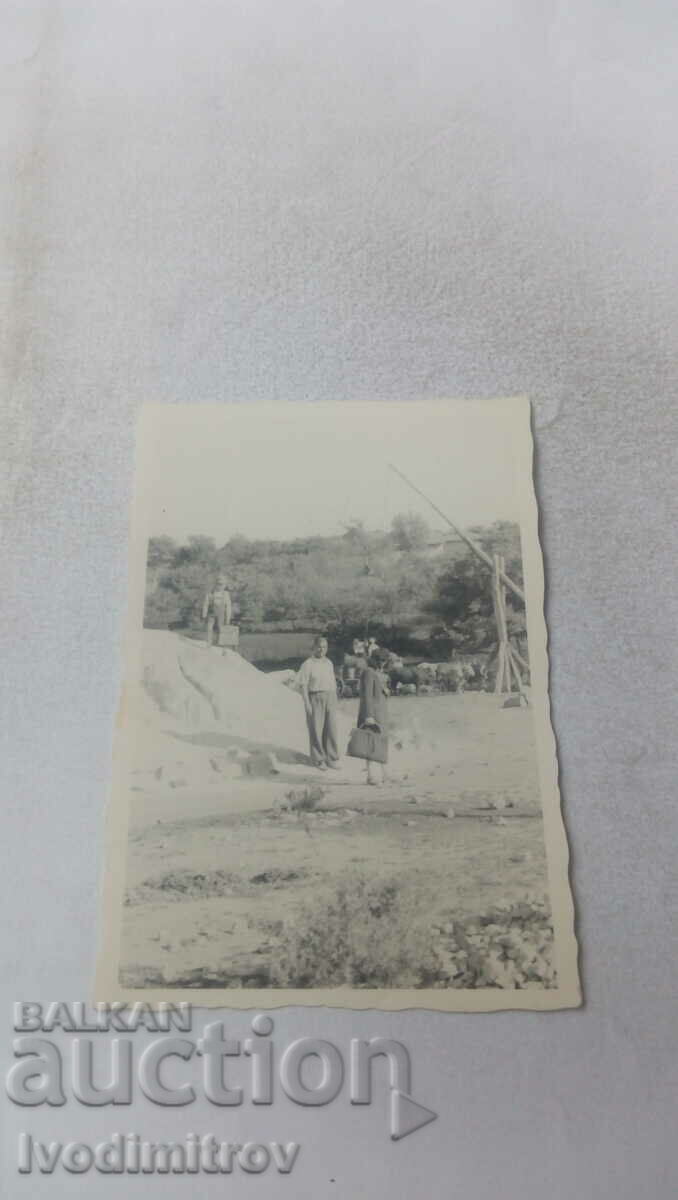 Photo Man and woman at a water well