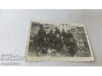 Photo Sergeants and soldiers sitting on stones