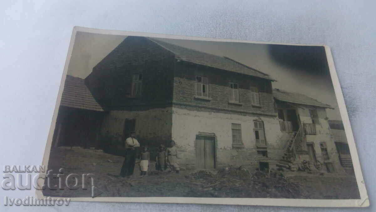 Φωτογραφία Ένας άντρας και τρία κορίτσια μπροστά από το σπίτι του