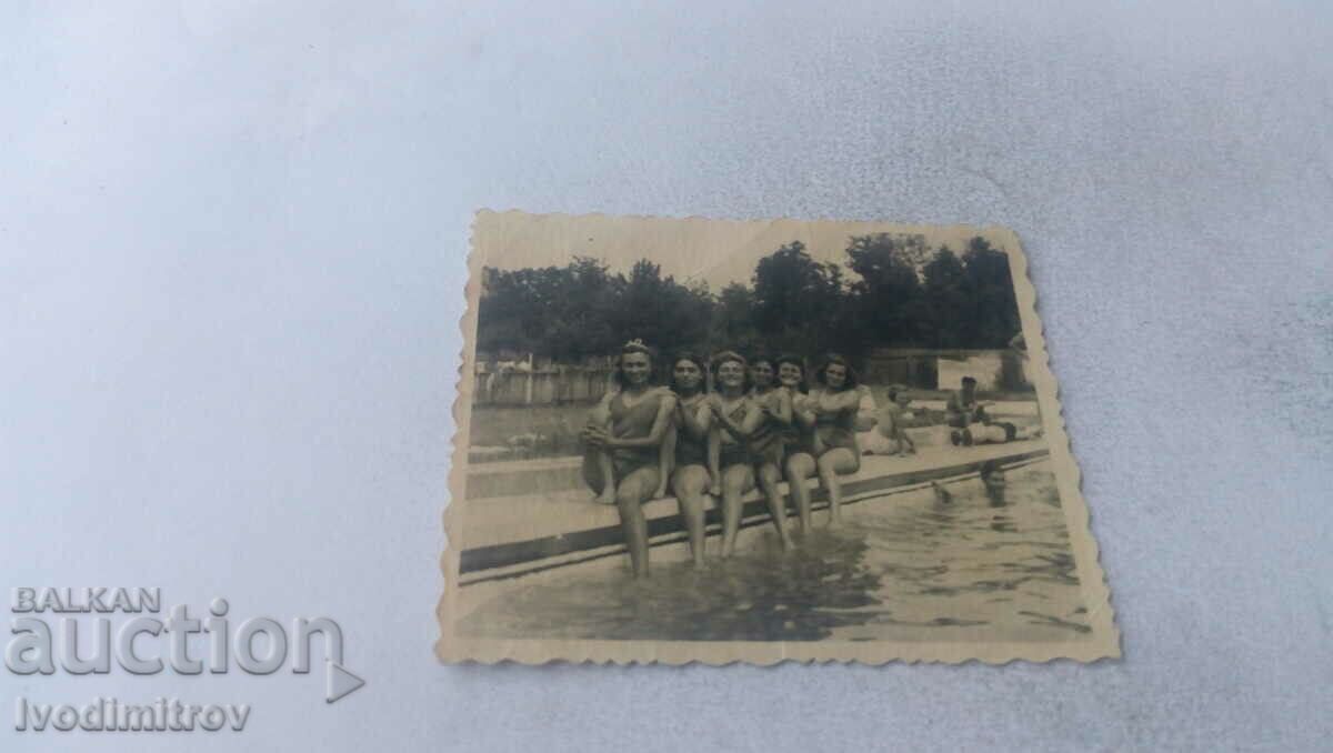 Εικόνα Πέντε γυναίκες που κάθονται σε σουβέρ δίπλα στην πισίνα