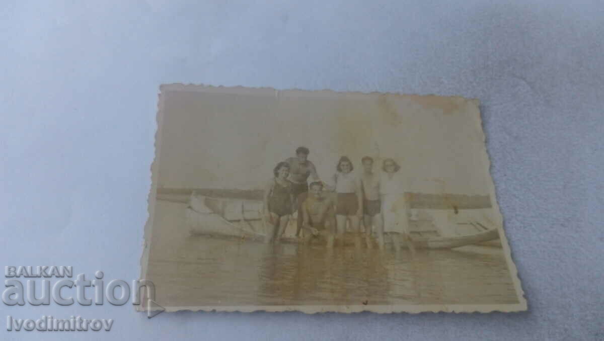 Photo Three men and three women on a boat in the sea