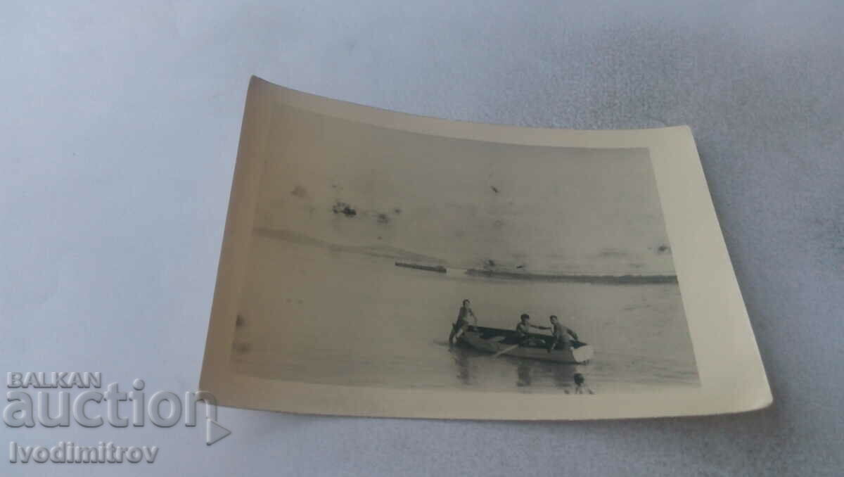 Imagine Trei bărbați cu o barcă în râu