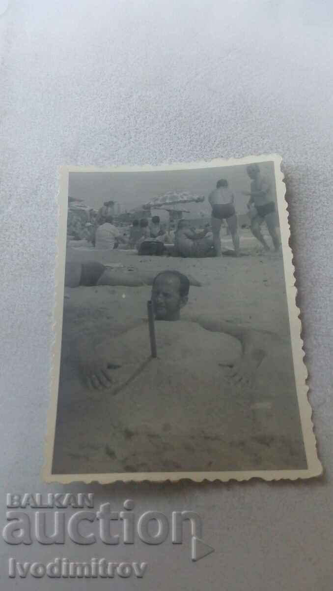 Снимка Мъж заровен в пясъка на плажа
