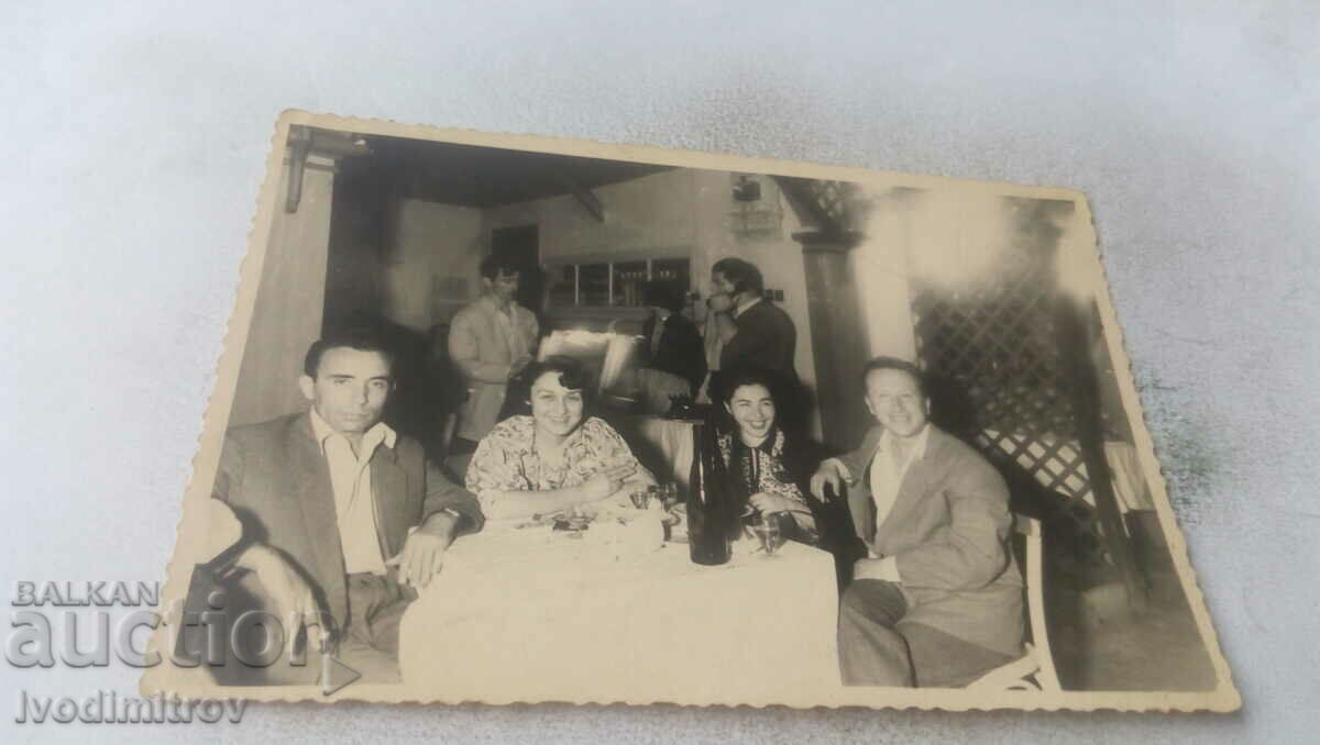 Foto Doi bărbați și două femei la un pahar într-un restaurant