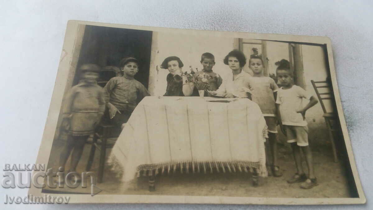 Снимка Жени и деца около маса в двора