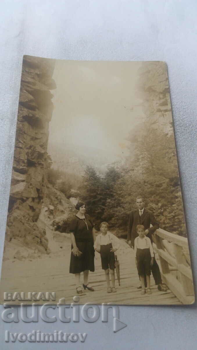 Κα Άνδρας γυναίκα και δύο αγόρια σε μια ξύλινη πλατφόρμα στα βουνά