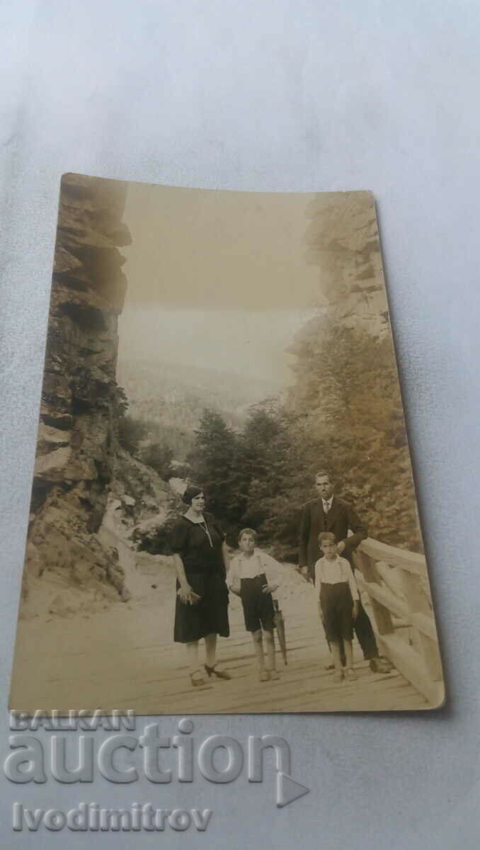 Doamna bărbat femeie și doi băieți pe o platformă de lemn în munți