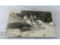 Photo Man, woman and two boys on stones by a stream