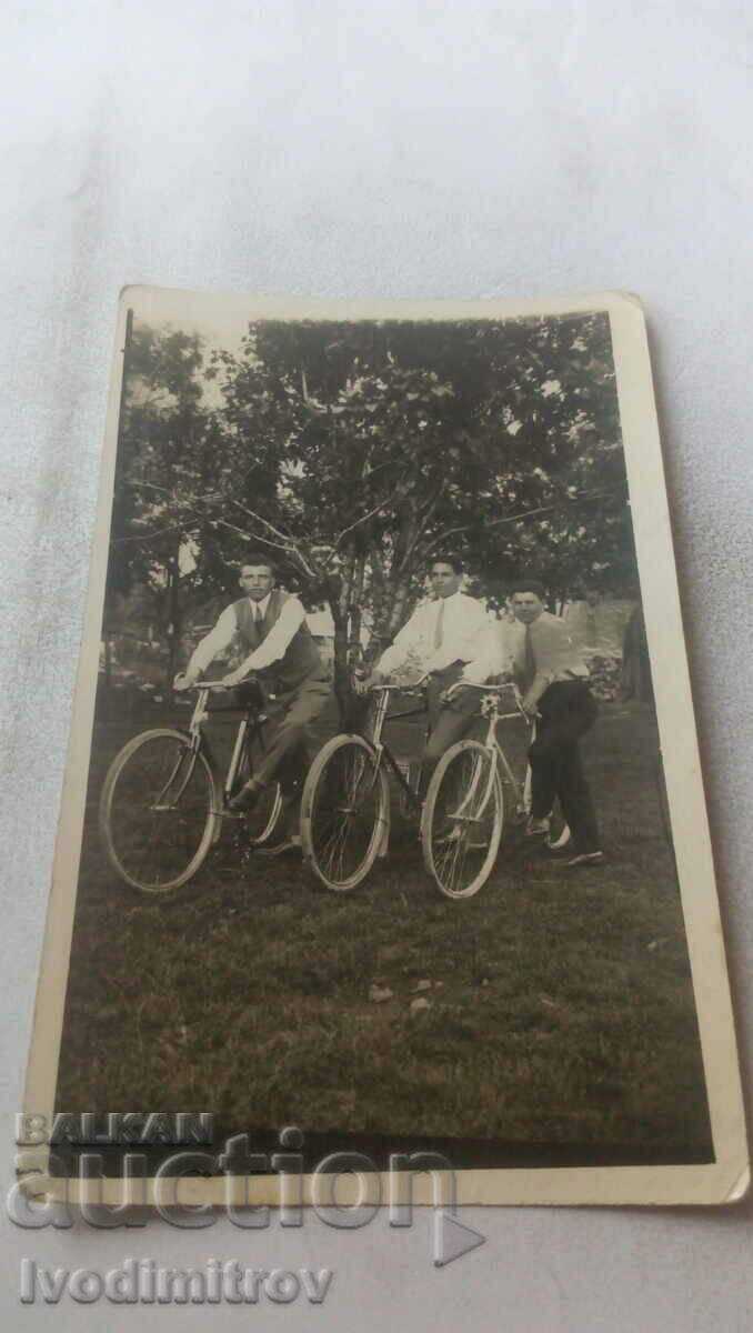 Photo Three young men with vintage bicycles