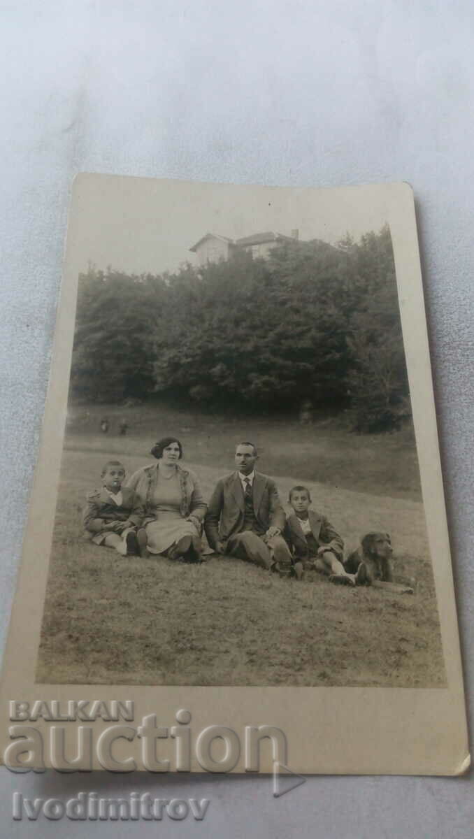 Photo Kostenets Man woman two boys and a black dog on a meadow