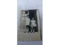 Φωτογραφία Δύο κοριτσάκια μπροστά από την είσοδο ενός σπιτιού