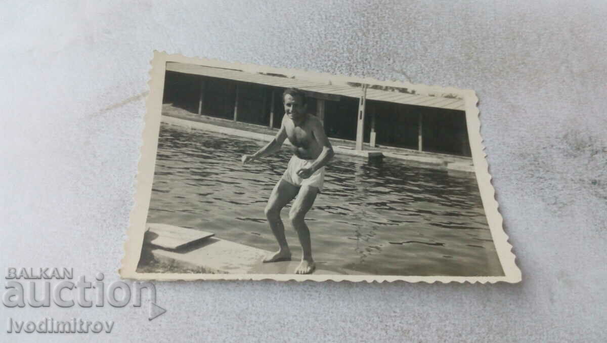 Fotografie Bărbat în costum de baie lângă piscină