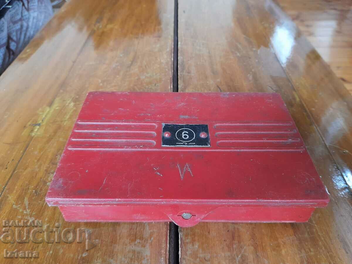 O cutie veche cu un set de litere și numere metalice