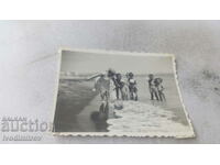 Fotografie O femeie și șase copii mici pe plajă
