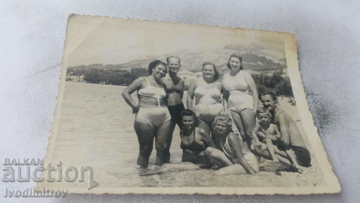 Photo Two men women and a small boy on the beach 1950