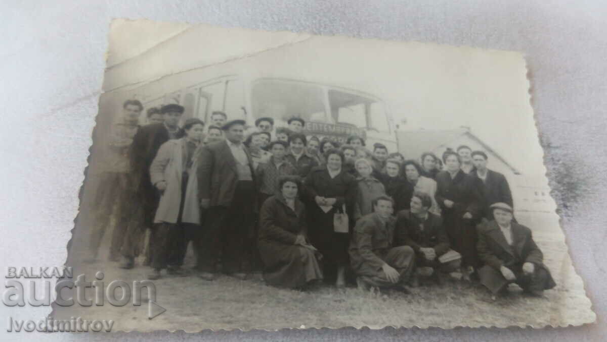 Fotografie Bărbați și femei în fața unui autobuz de epocă