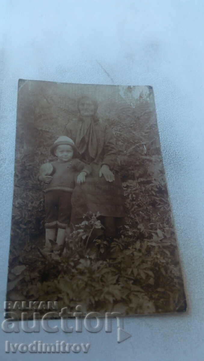 Φωτογραφία Μια ηλικιωμένη γυναίκα και ένα μικρό αγόρι στον κήπο
