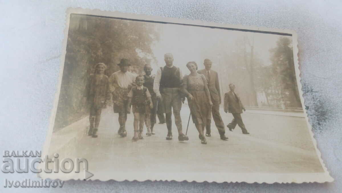 Photo Men, women and children walking on the sidewalk