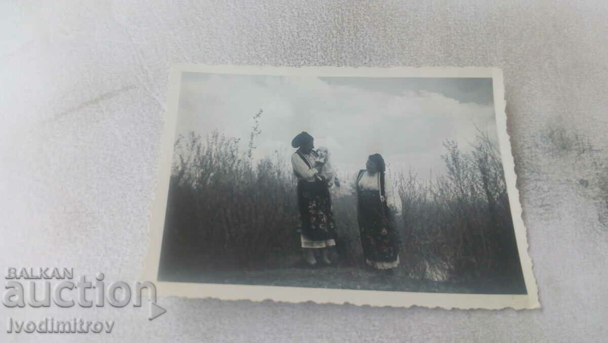 Φωτογραφία Δύο γυναίκες με ένα λευκό κανίς